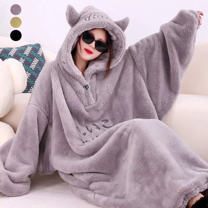 A cozy hooded blanket with an oversized design, featuring soft plush material and playful ear details on the hood, perfect for lounging at home and staying warm in style.