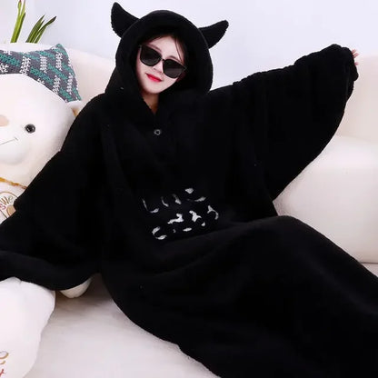 A cozy hooded blanket with an oversized design, featuring soft plush material and playful ear details on the hood, perfect for lounging at home and staying warm in style.