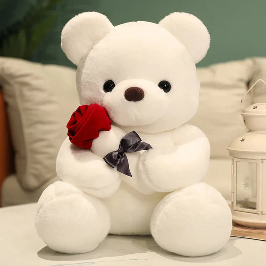 A plush toy featuring an adorable bear holding a rose and wearing a bow, designed as a perfect gift-ready item for spreading joy and love.
