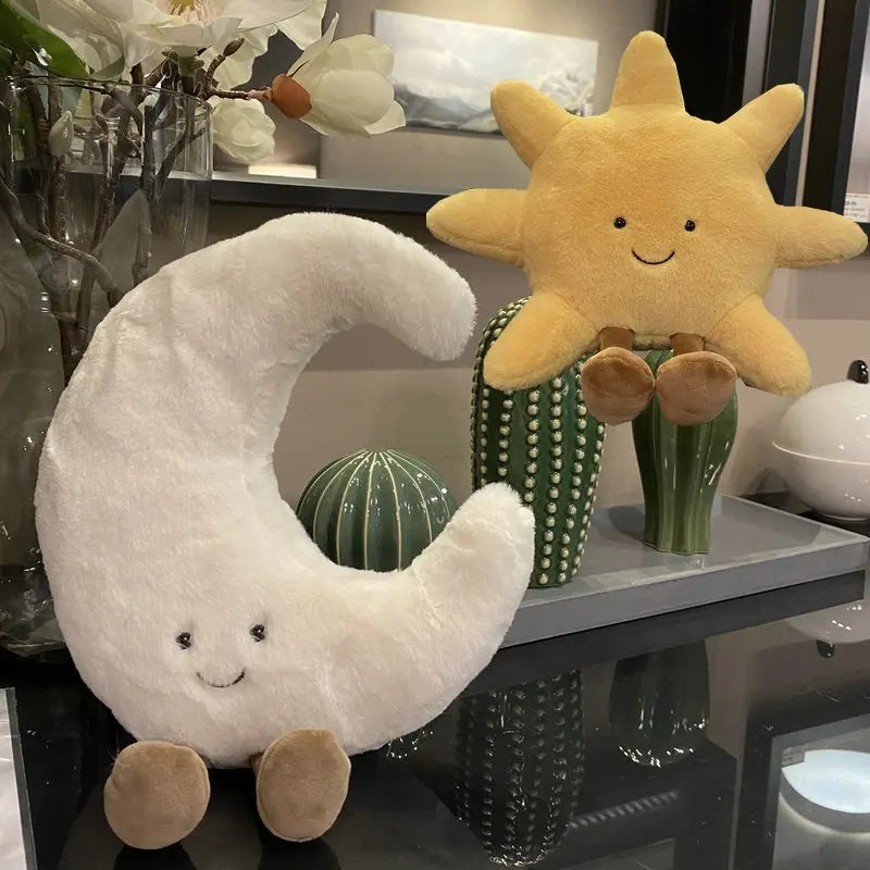 A plush set featuring a cheerful sun and a crescent moon with adorable smiling faces and soft, huggable designs, perfect for snuggles, room decor, or gifting.