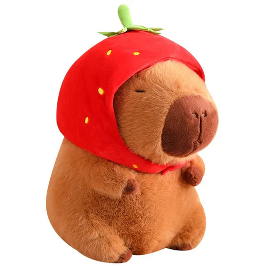 A plush capybara toy wearing a playful hat, holding a cute cup with a whimsical design, placed on a wooden table.