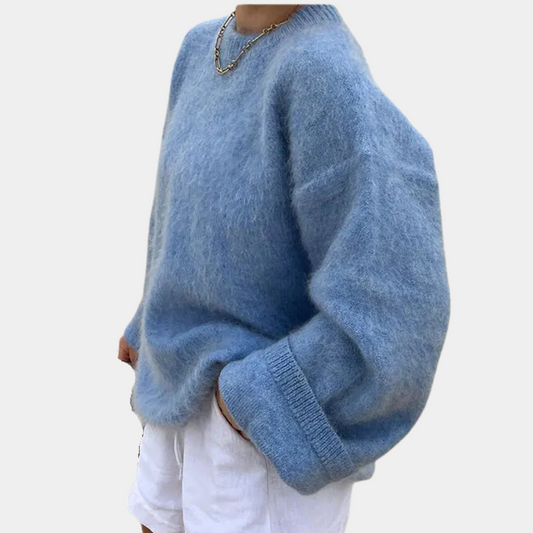 Side view of a woman wearing a relaxed fit knit sweater paired with shorts, showcasing the comfortable and cozy design of the sweater.