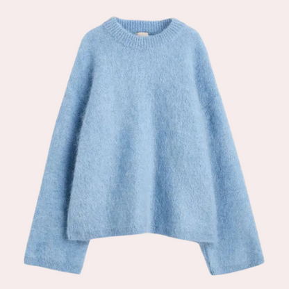Side view of a woman wearing a relaxed fit knit sweater paired with shorts, showcasing the comfortable and cozy design of the sweater.