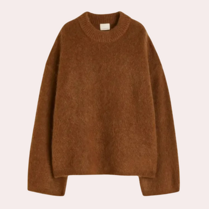 Side view of a woman wearing a relaxed fit knit sweater paired with shorts, showcasing the comfortable and cozy design of the sweater.