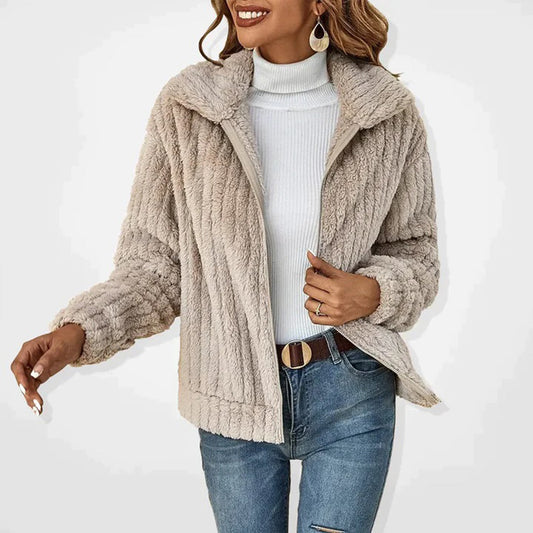 Woman wearing a plush jacket with a cozy texture, styled with a turtleneck sweater and jeans, creating a chic and comfortable look.