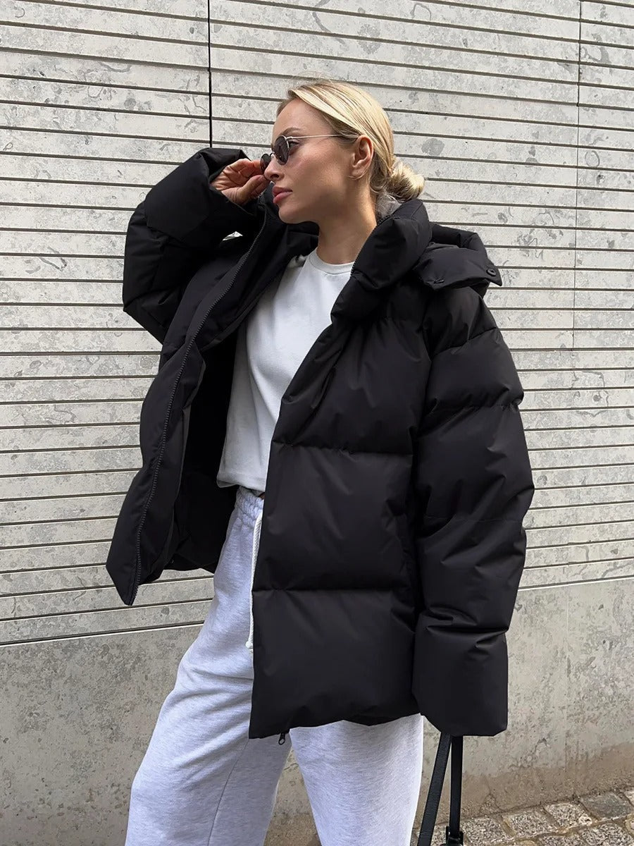 A women's oversized puffer jacket with a stylish design, featuring a cozy and relaxed fit, perfect for layering and providing warmth during the colder months.