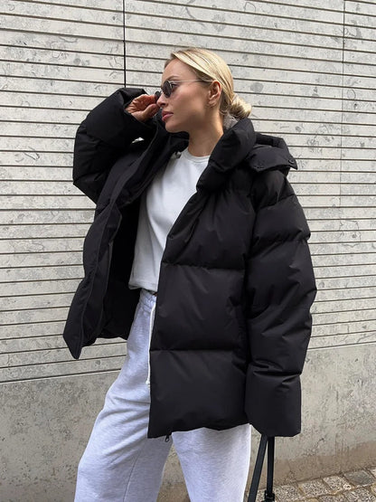 A women's oversized puffer jacket with a stylish design, featuring a cozy and relaxed fit, perfect for layering and providing warmth during the colder months.