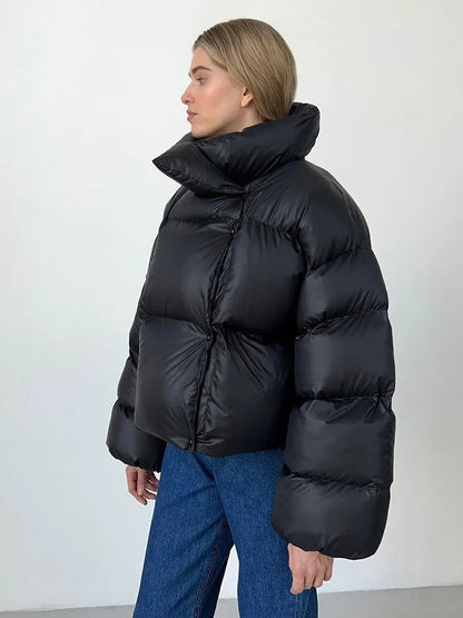 A women's oversized puffer jacket with a stylish design, featuring a cozy and relaxed fit, perfect for layering and providing warmth during the colder months.
