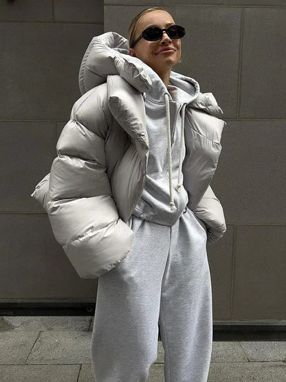 A women's oversized puffer jacket with a stylish design, featuring a cozy and relaxed fit, perfect for layering and providing warmth during the colder months.