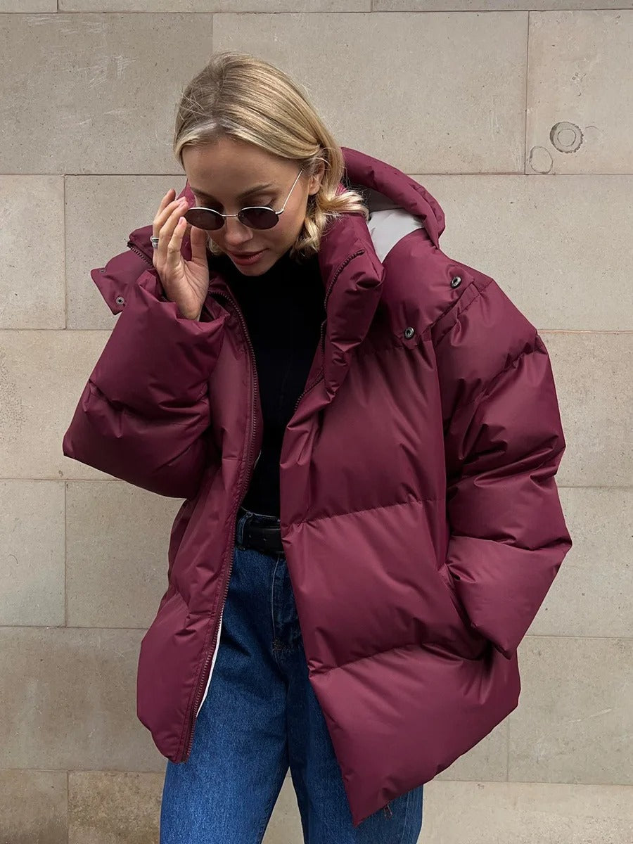 A women's oversized puffer jacket with a stylish design, featuring a cozy and relaxed fit, perfect for layering and providing warmth during the colder months.