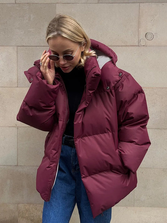 A women's oversized puffer jacket with a stylish design, featuring a cozy and relaxed fit, perfect for layering and providing warmth during the colder months.