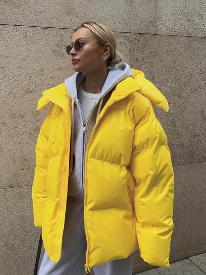 A women's oversized puffer jacket with a stylish design, featuring a cozy and relaxed fit, perfect for layering and providing warmth during the colder months.